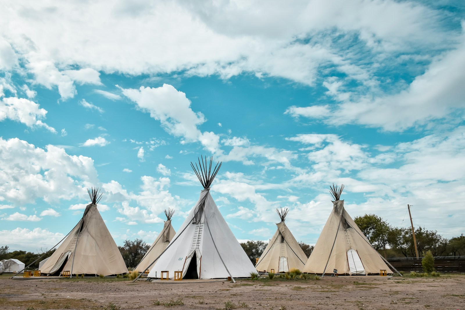 five tippi tents during day time