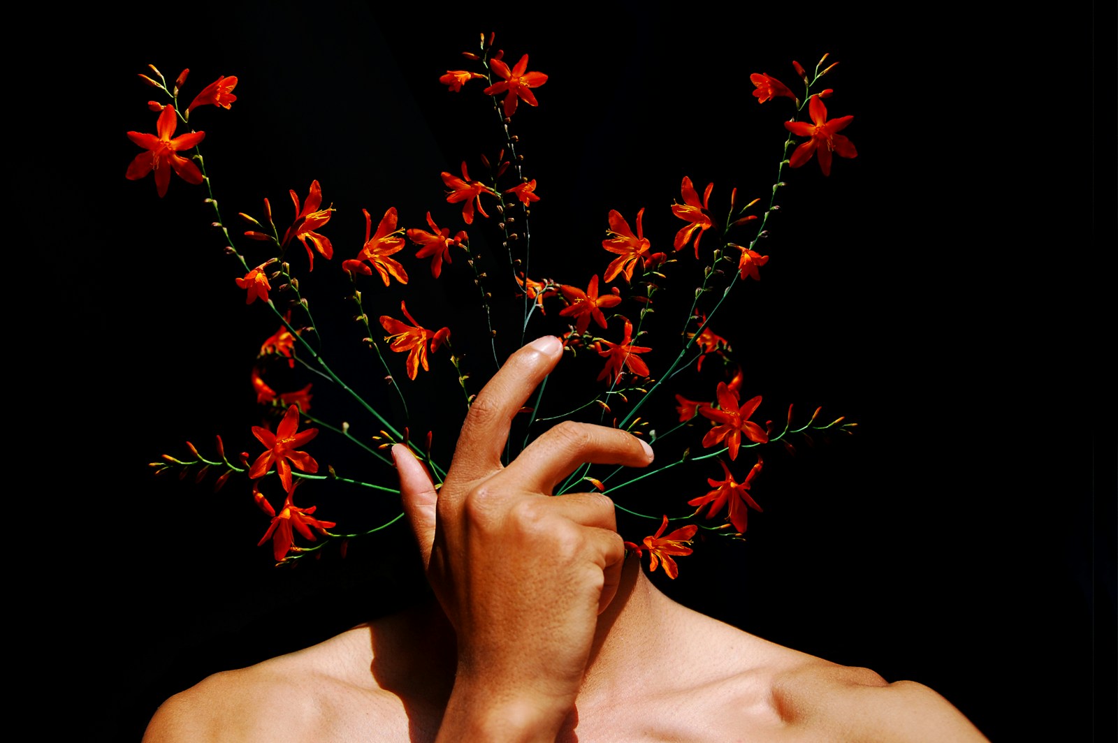 A man holding a bouquet of flowers in front of his face
