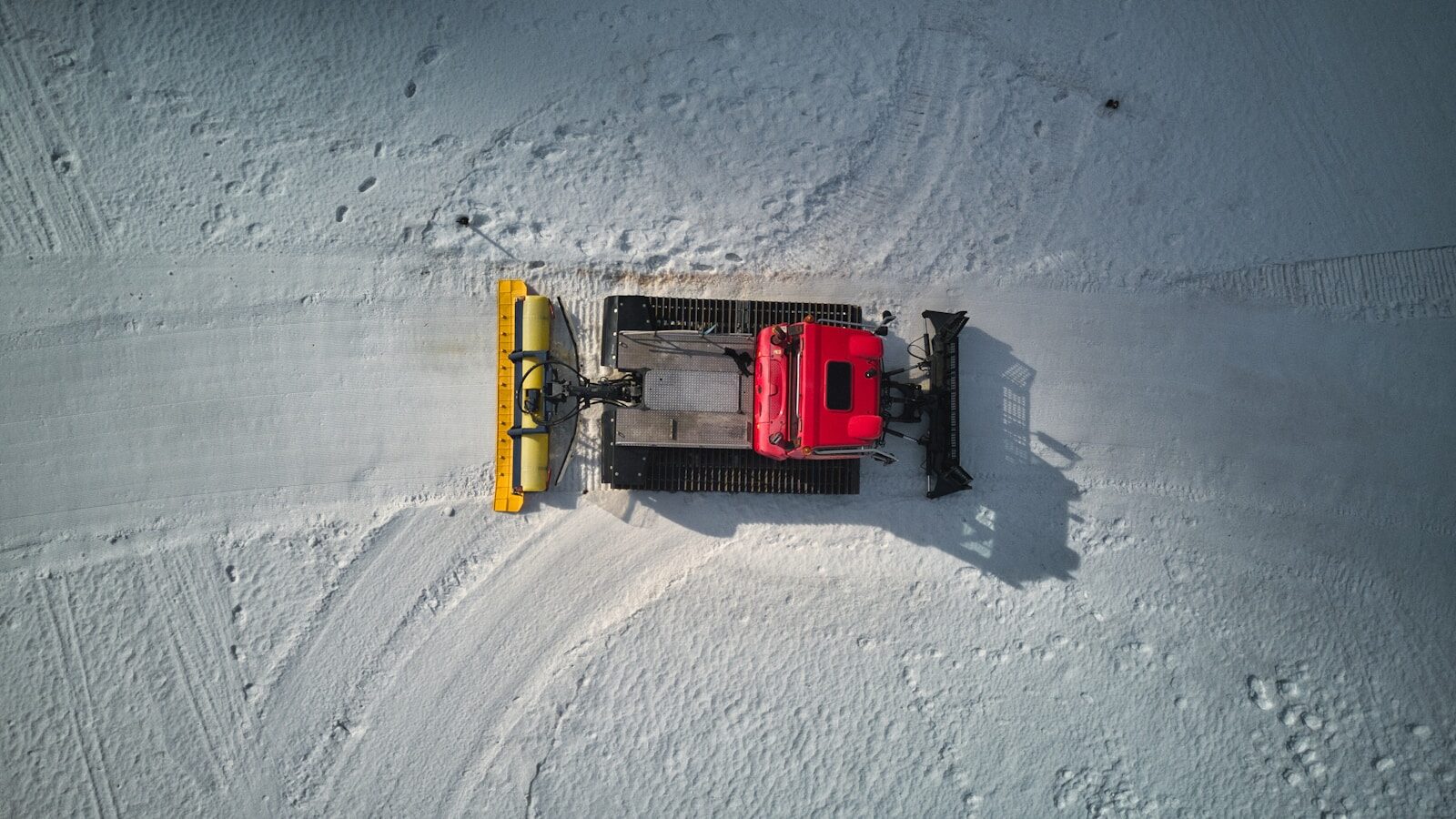 a snow plow sitting on top of snow covered ground